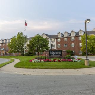Exterior view of a hotel with a landscaped entrance and signage.