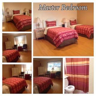 A cozy master bedroom featuring twin beds with vibrant bedding, complemented by a stylish bathroom.