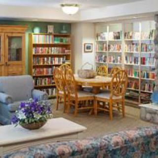 A cozy library setting with comfortable seating and bookshelves filled with books.