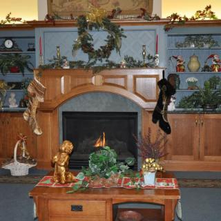 A cozy Christmas-themed living room with a decorated fireplace and stockings hanging from the mantel.