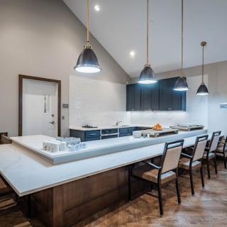 A modern kitchen with a spacious countertop and sleek pendant lighting.