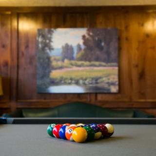A neatly arranged set of pool balls on a billiards table in a cozy game room.