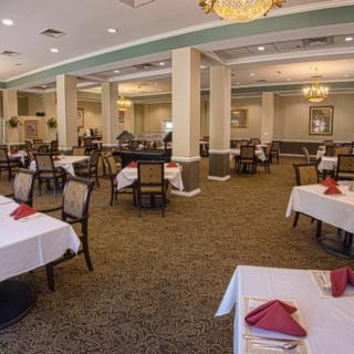 An elegant dining area with neatly arranged tables and chandeliers.
