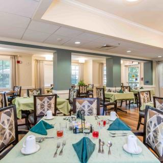 A well-arranged dining area with neatly set tables and chairs, featuring elegant table settings and decor.