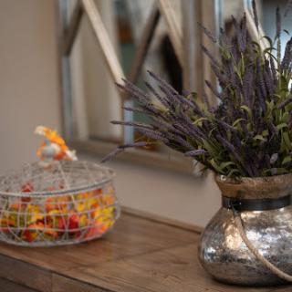 A beautifully arranged interior scene featuring a vase of lavender and a colorful bowl of candy on a wooden table.