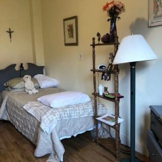 Cozy bedroom with a single bed and decorative shelving.