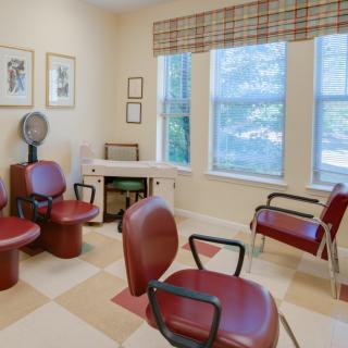 A cozy hair salon waiting area with comfortable seating and natural light.