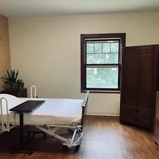 A simple room with a hospital bed and window.