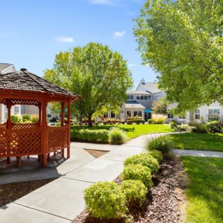 A serene garden with a gazebo and well-maintained pathways on a sunny day.
