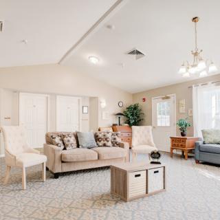 A spacious and well-lit living room featuring comfortable seating, modern decor, and natural lighting.