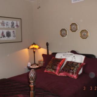 Cozy bedroom with decorative pillows and a vintage lamp.
