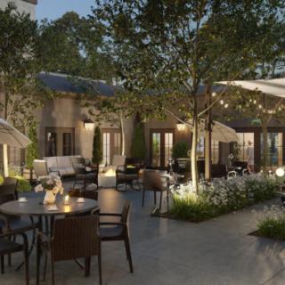 A charming outdoor patio with string lights creates a cozy evening dining atmosphere.