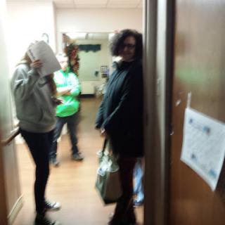 A candid moment captured in a hallway with several individuals engaging in conversation.
