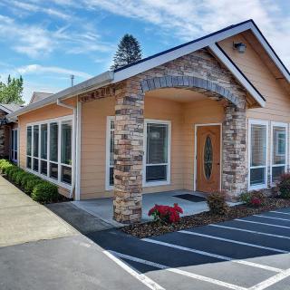 A modern office building with a stone facade and well-maintained landscaping.