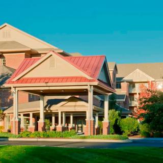 A hotel building with a prominent entrance and surrounding greenery.