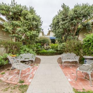 A serene garden pathway with benches and lush greenery.