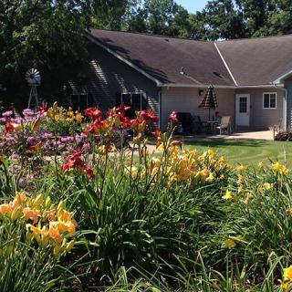 A beautiful garden with colorful flowers in front of a house.