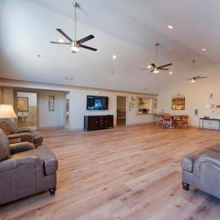 A spacious and inviting living room featuring modern decor, ceiling fans, and hardwood flooring.