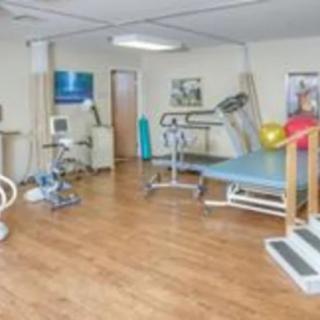 A physical therapy room equipped with various exercise and rehabilitation equipment.