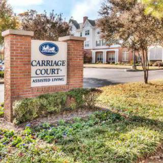 Sign for Carriage Court Assisted Living with building in the background.