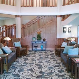 A welcoming lobby area with comfortable seating and a beautiful wooden staircase.