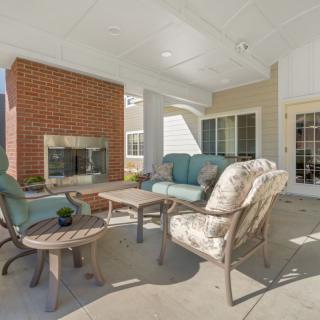 A cozy outdoor patio with comfortable seating and a brick fireplace.
