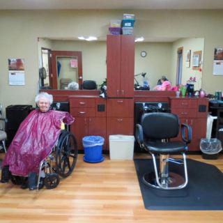 A person in a wheelchair at a hair salon, preparing for a haircut.