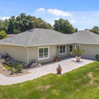A single-story house with a patio and surrounding landscaping.