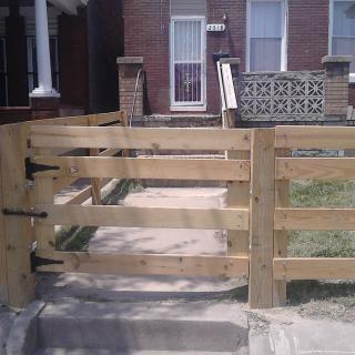 A newly installed wooden gate in front of a house.