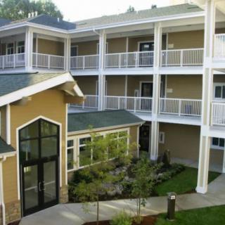 A modern residential apartment complex with spacious balconies and a central courtyard.