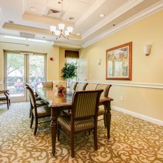 A well-appointed dining room featuring a long table with chairs, elegant lighting, and tasteful decor.