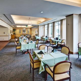 Elegant dining room with tables and chairs set for guests.