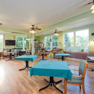 A cozy dining area with teal tables and plenty of natural light.
