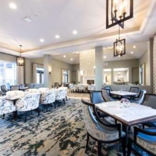 A modern and spacious restaurant interior with elegant lighting and well-arranged tables and chairs.