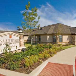 A welcoming residential community with well-maintained landscaping and a clear blue sky.