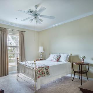 Cozy and well-lit bedroom featuring a comfortable bed and elegant decor.