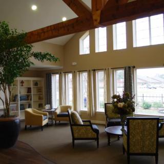A spacious lounge area with large windows, comfortable seating, and natural lighting.