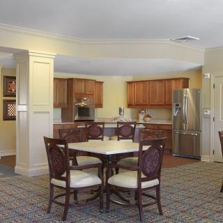 A cozy kitchen and dining area with wooden cabinets, a round table, and chairs.