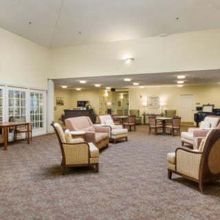 A spacious lounge area featuring comfortable seating and warm lighting.