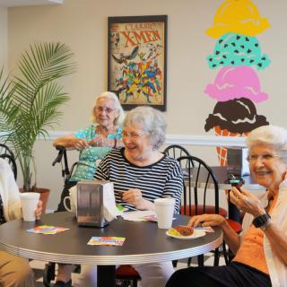 A group of seniors enjoying drinks and conversation at a cafe.