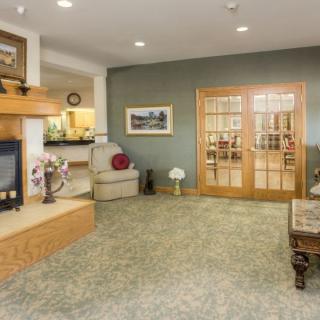 A cozy lobby area featuring a fireplace, seating arrangement, and wooden doors.