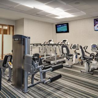 A well-equipped gym with various exercise machines, including stationary bikes and treadmills.
