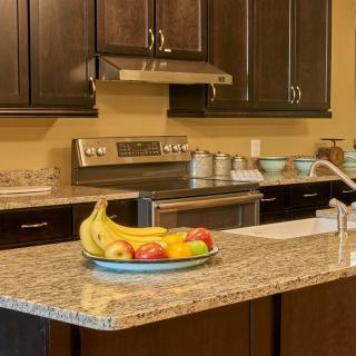 Modern kitchen with granite countertops and a fruit bowl centerpiece.