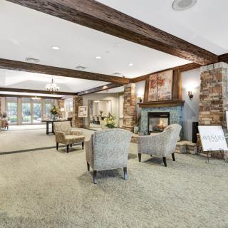 A cozy lobby area with a fireplace, comfortable seating, and warm decor.