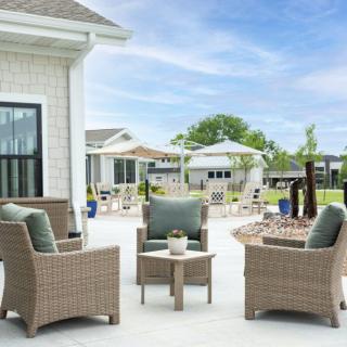 A cozy outdoor patio setup with wicker chairs and a small table.