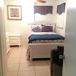 A cozy bedroom with a white bed and matching furniture.