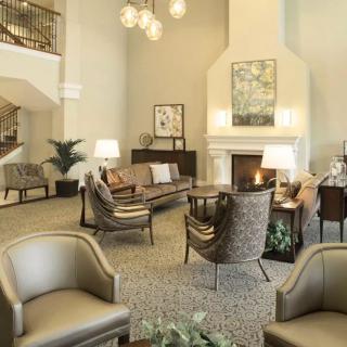 A cozy and modern lobby with elegant furniture, a fireplace, and warm lighting.