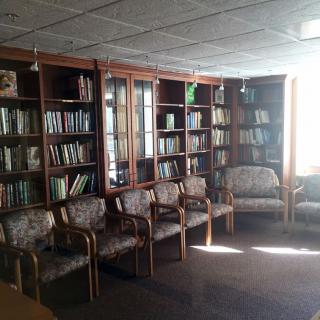 A cozy library corner with shelves full of books and comfortable seating.