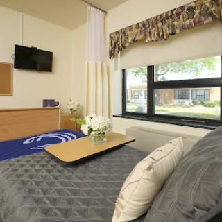 A cozy and modern bedroom featuring a comfortable bed, a small table, and a television.