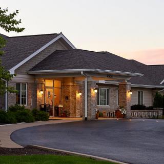 A cozy residential building with a warmly lit entrance at dusk.